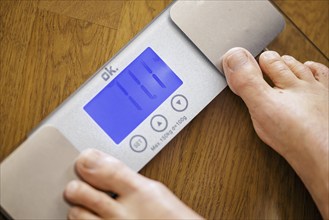 Symbolic photo on the subject of body weight. The feet of a 60-year-old person can be seen next to