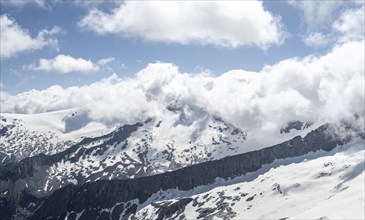 View of mountain peak Schwarzenstein with clouds and snow, mountain landscape with rocky peaks and