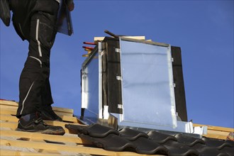 Roofer works on the chimney cladding