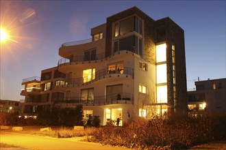 Symbolic image of modern living: Night shot of a modern apartment building in urban style