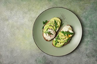 Sandwich with cream cheese, sliced avocado and boiled egg, arugula, on grainy bread, homemade,