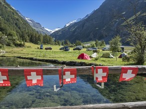 Tents and camper vans on a small campsite, village Zinal, mountain range in the back, Val