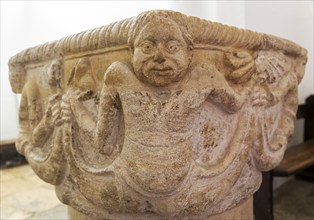 Carved stonework Merman figure baptismal font, church of Saint Peter, Cambridge, Cambridgeshire,