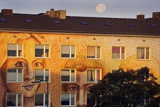 Wall painting Faces by Klaus Klinger on an apartment block with a full moon, street art,