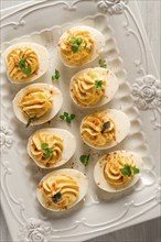 Boiled eggs stuffed with yolk with mayonnaise, on a white plate, selective focus, blurry, close-up,