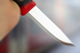 Symbolic image of a knife attack: close-up of a knife in a man's hand