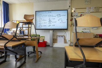 Classroom of a fourth grade, after school, the building is older but in good condition, modern