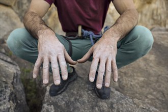 Close-up of a climber's chalk-covered hands, emphasizing grip and preparation for climbing