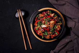 Asian cuisine, teriyaki meat with vegetables, in a cast-iron frying pan, close-up, no people