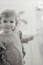 A smiling child holds a balloon in a black and white picture