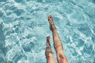 Two legs floating in the water in a clear blue pool