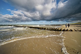 Stormy day, high waves breaking on the groynes on the Baltic Sea beach, cloudy mood, Baltic seaside