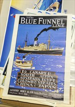 Pile of vintage posters on sale at auction, The Blue Funnel Line shipping company reproduction