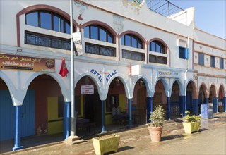 Historic buildings shops and hotel in arcaded shopping street in town centre, Mirleft, southern