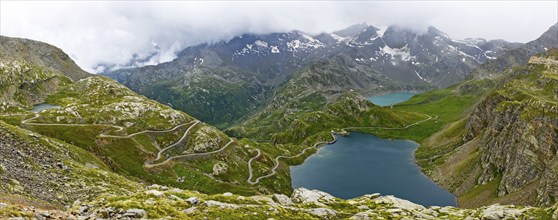 Panoramic view of left serpentines narrow bends from ascent pass road to alpine pass Colle del Col