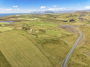 Aerial view of road leading to Cape Dyrholaey, lava formations and meadows, southern coast,