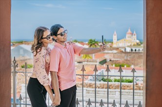 Happy tourists taking self portrait at the viewpoint of the La Merced church, Granada. Tourist