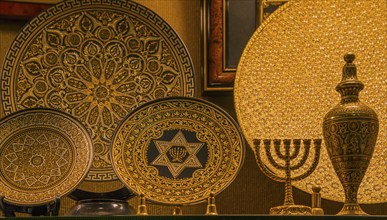 Gold-decorated decorative plates with intricate patterns and symbols, including a menorah and Star