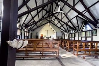 Interior of the nave of Notre-Dame Auxiliatrice de Cap Malheureux church with exposed roof beams,