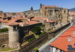 Historic castle and neighbouring buildings with red tiled roofs on a sunny day, aerial view,