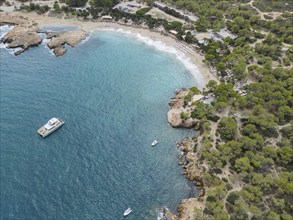 Aerial view of a coastline with beach, turquoise water and surrounding trees, Cala Bassa, Ibiza,