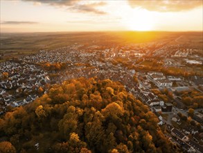 Aerial view of a town at sunset surrounded by autumnal forest, Herrenberg, Germany, Europe