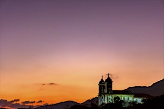 Tower of an old baroque church and mountains in the city of Ouro Preto in Minas Gerais during