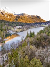 Evening atmosphere at the lake with reflections of the mountains and forests in the water,