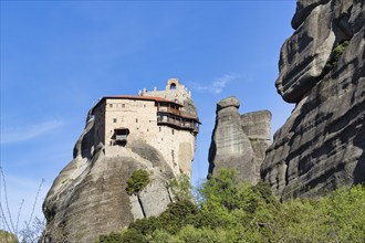 Monastery of St Nikolaos Anapavsas on a rock, sandstone formation, Meteora, blue sky, spring