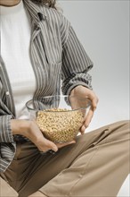 Unrecognizable woman with glass bowl full of chickpeas in hands