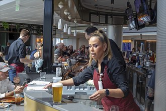 Denver, Colorado, Workers at bar dough, an airport restaurant and bar, serve travelers at Denver