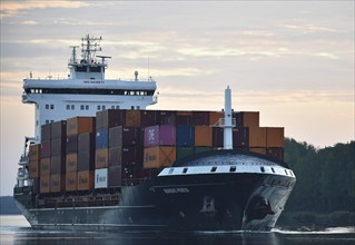 Container ship Nordic Porto sailing at sunrise in the Kiel Canal, Kiel Canal, Schleswig-Holstein,