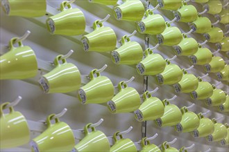 Green drinking cups hanging in an IKEA store create abstract pattern