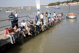 People crabbing from jetty, Felixstowe Ferry, Suffolk, England, United Kingdom, Europe