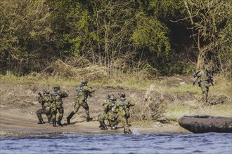 Czech and German soldiers launch an inflatable boat into the Elbe as part of the military exercise