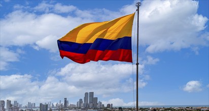 Flag wavering in front of scenic view of Cartagena modern skyline near historic city center and