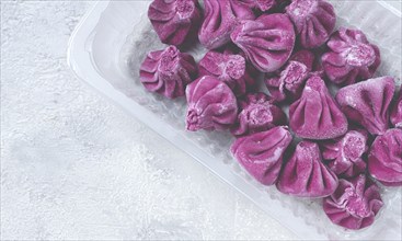 Freshly frozen beetroot khinkali, in a container, top view, no people