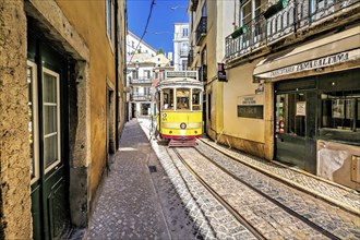 A vintage yellow tram navigates a narrow cobblestone lane in Lisbon, reflecting a sunny, vibrant