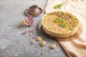 Traditional american sweet pumpkin pie decorated with mint, sesame and pumpkin seeds with cup of