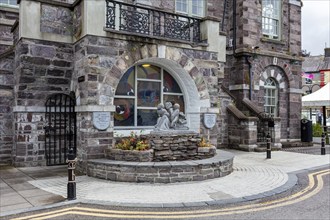 Stone building with sculpture in the foreground and creative details, Macroom