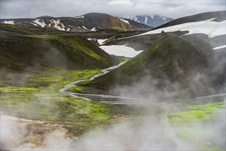 Colourful volcanic landscape with hills and snow, volcanic steaming hot springs, Laugavegur