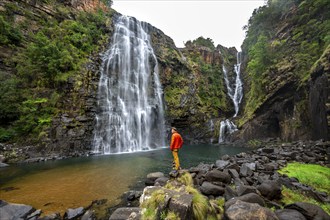 Young man standing in front of a waterfall, Lisbon Falls, long exposure, near Graskop, Mpumalanga,