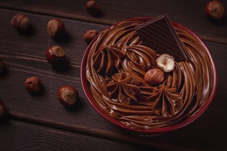 Chocolate nut paste, mousse, pasta, in a cup, on a wooden table, top view, selective focus, no