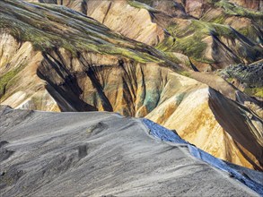 Hikers decending the slopes of Mt. Blahnukur, early snow, colorful rhyolite mountains, lava field,