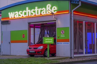 Car in an automatic car wash, car wash tunnel, vehicle drying after washing with warm compressed