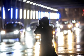 Illuminated subway at the main railway station, pedestrians at a pedestrian crossing, rainy