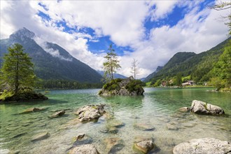 Hintersee near Ramsau with clear green water, surrounded by forests and mountains under a cloudy