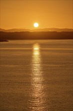 Atmospheric landscape scene at sunrise, calm sea and silhouetted islands in the twilight, autumn,