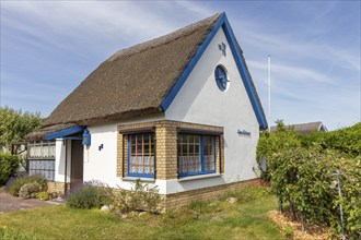 Small thatched house in a green garden in sunny weather, Rügen