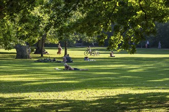 People in the park, sunlight falling through oak trees, Frederiksberg Park, Copenhagen, Denmark,